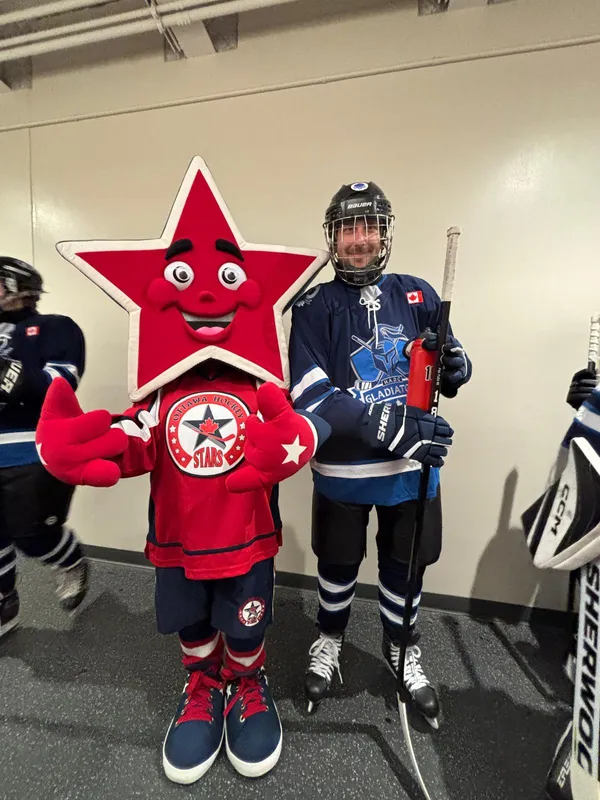 A Gladiators player posing with a star mascot before a game